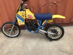 Yellow Suzuki RM80 dirt bike with blue seat and frame